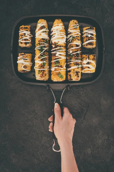 Mujer sosteniendo la parrilla con maíz - foto de stock