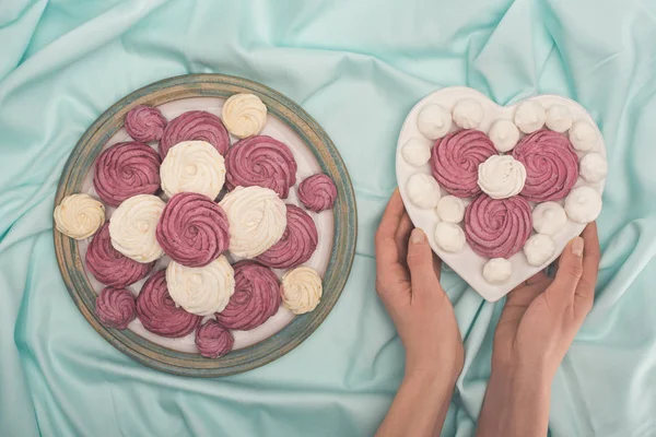 Hände halten Teller mit Marshmallows — Stockfoto