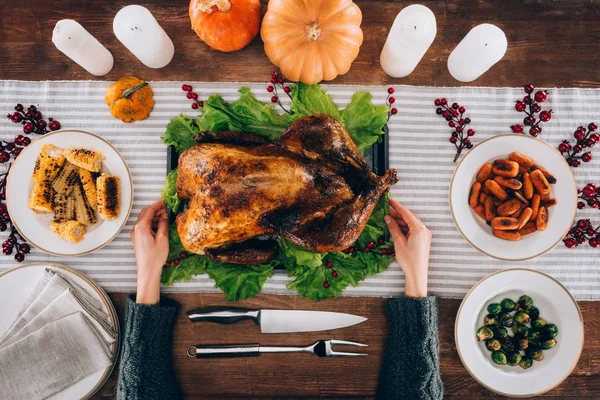 Hombre sirviendo pavo al horno en la mesa - foto de stock