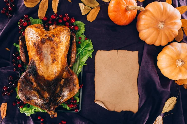 Baked turkey with pumpkins and sheet of paper — Stock Photo