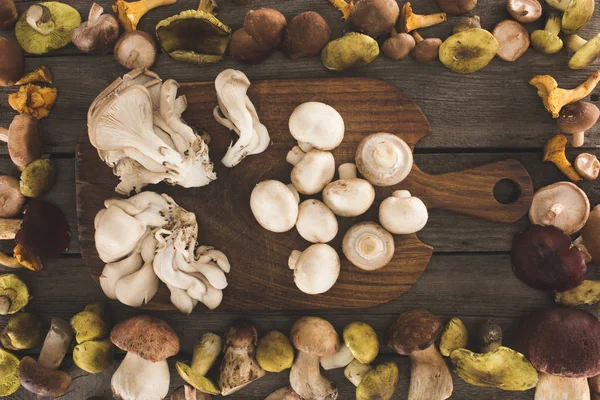 Different types of mushrooms on cutting board — Stock Photo