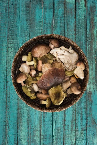 Wicker plate with different mushrooms — Stock Photo