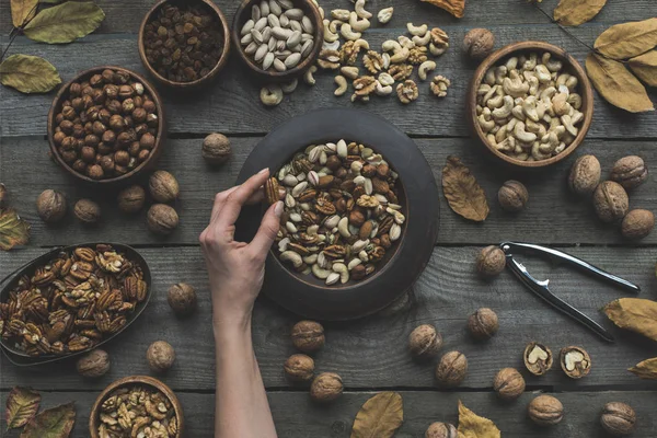 Assorted nuts and autumn leaves — Stock Photo
