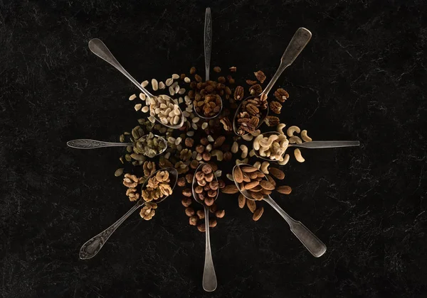 Assorted nuts in spoons — Stock Photo