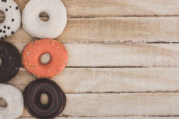 Donuts on wooden table top — Stock Photo