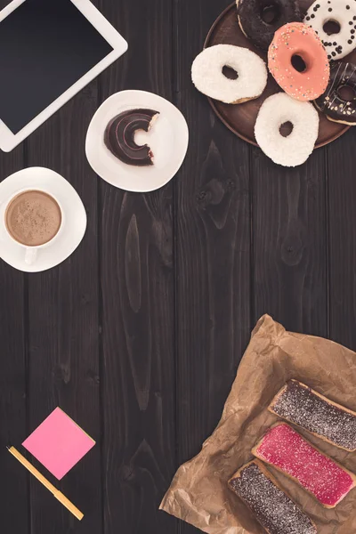 Пончики, кофе и цифровой планшет — стоковое фото
