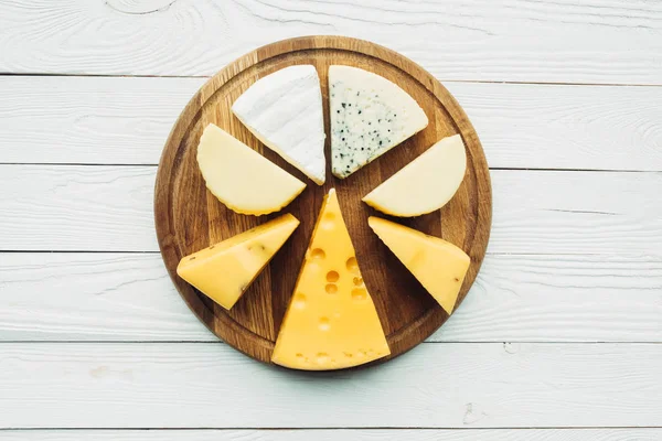 Assorted types of cheese on cutting board — Stock Photo