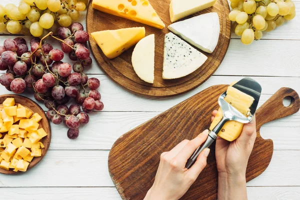 Woman cutting cheese — Stock Photo