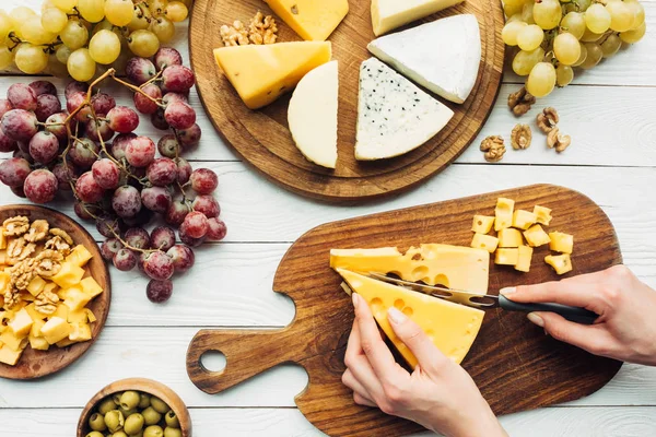 Woman cutting cheese — Stock Photo