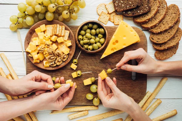 Mujeres haciendo canapés con queso - foto de stock