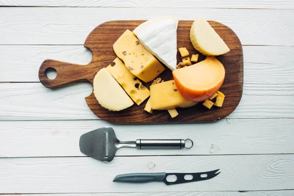 Assorted types of cheese and cutlery — Stock Photo