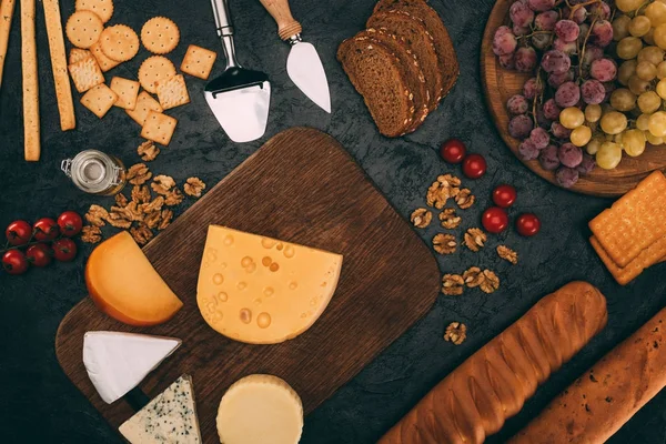 Various cheese types, bread and grapes — Stock Photo