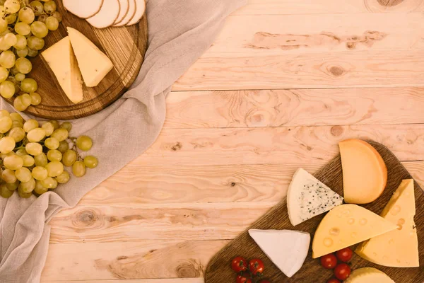 Various types of cheese on cutting boards — Stock Photo