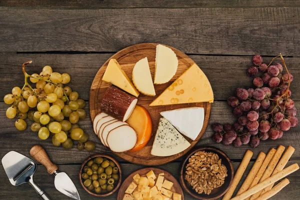 Varios tipos de queso en la tabla de cortar - foto de stock