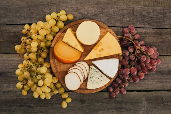 Différents types de fromage sur planche à découper — Photo de stock