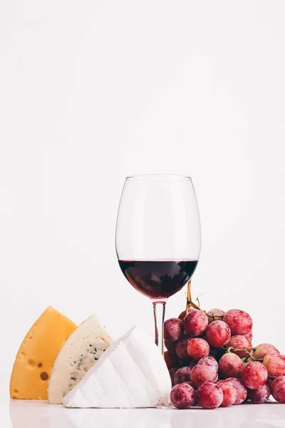 Queijo, copo de vinho tinto e uvas — Fotografia de Stock