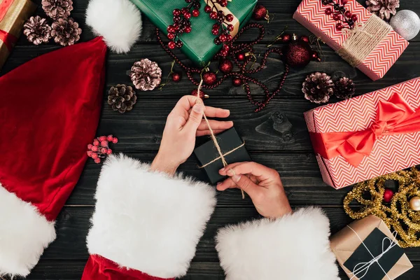 Santa claus packing christmas presents — Stock Photo