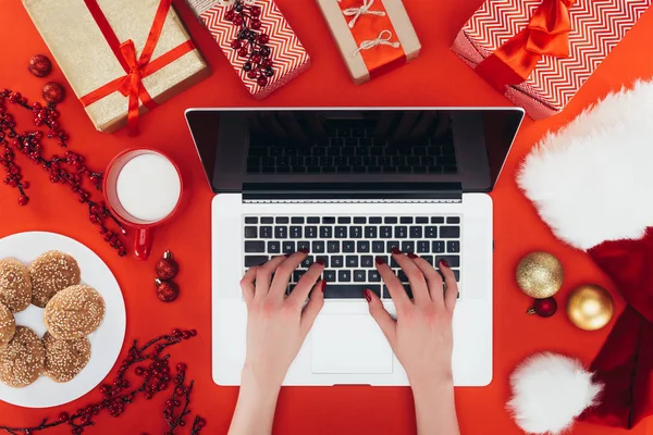 Woman using laptop at christmastime — Stock Photo