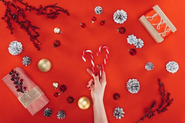 Hand with candy canes at christmastime — Stock Photo