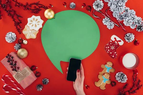 Рука со смартфоном и рождественская речь пузырь — стоковое фото