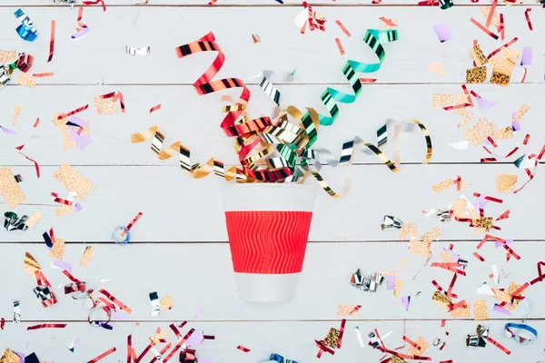 Confetti spilling out of paper cup — Stock Photo