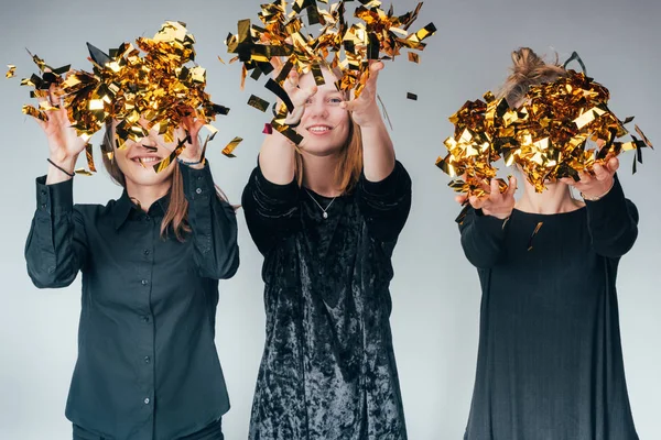 Mulheres jogando dourado confetti — Fotografia de Stock