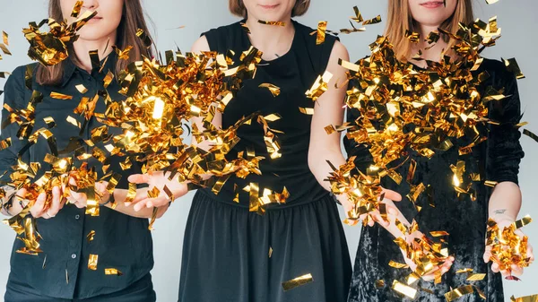 Mujeres lanzando confeti dorado - foto de stock