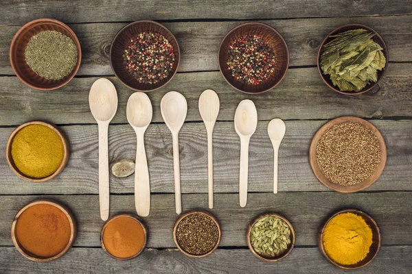 Wooden spoons among bowls with spices — Stock Photo