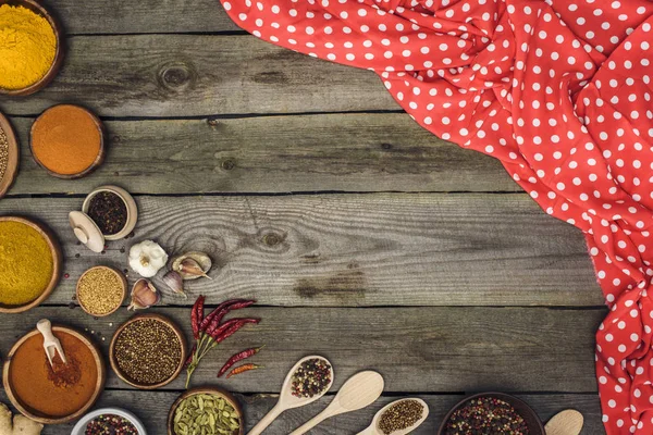 Red tablecloth and different spices — Stock Photo