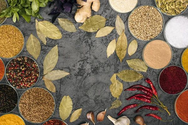 Spices in bowls and scattered bay leaves — Stock Photo