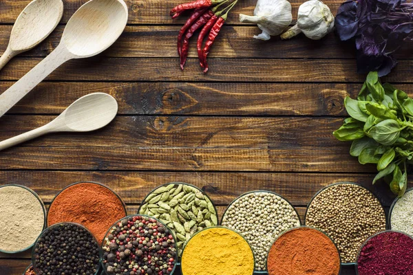 Bowls with spices and wooden spoons — Stock Photo