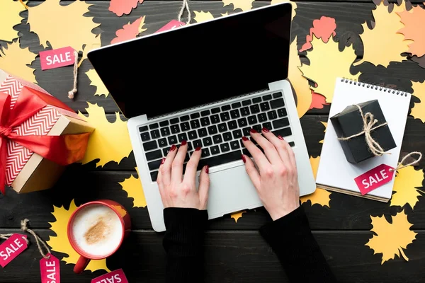 Laptop with presents and sale tags — Stock Photo