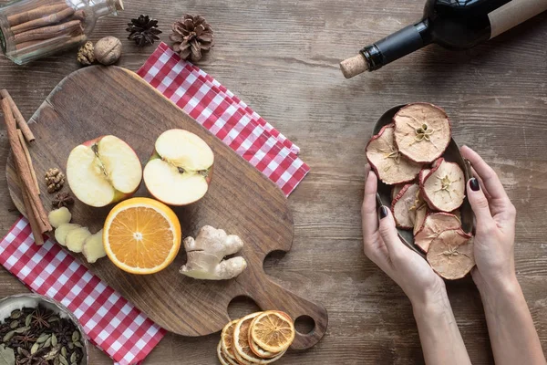 Mujer poniendo tazón con manzanas secas - foto de stock