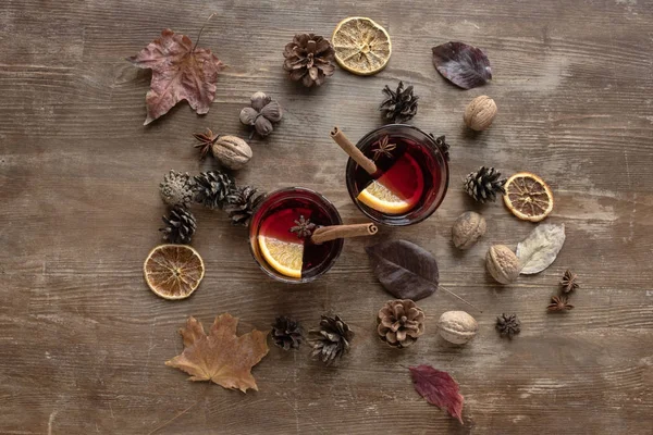 Mulled wine among pine cones and nuts — Stock Photo