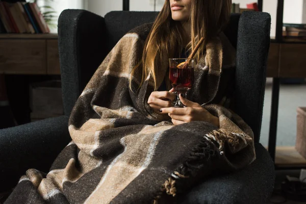 Mädchen sitzt im Sessel mit Glühwein — Stockfoto