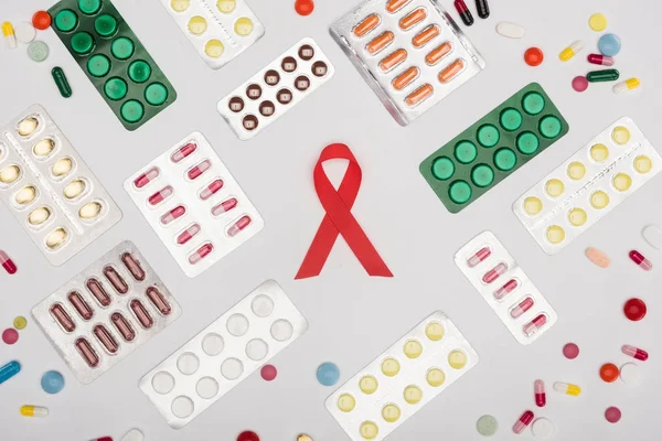 Red aids ribbon and pills — Stock Photo
