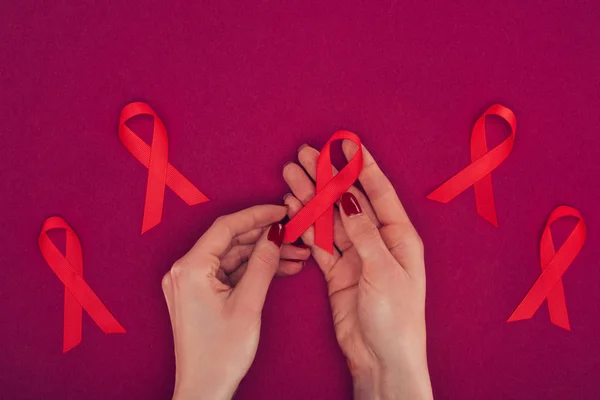 Hands with red aids ribbons — Stock Photo