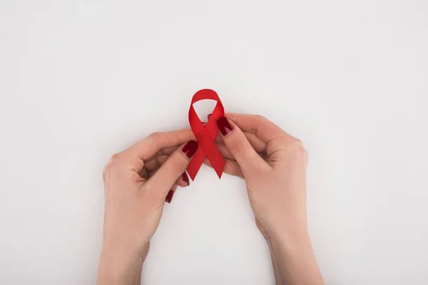 Hands holding red aids ribbon — Stock Photo
