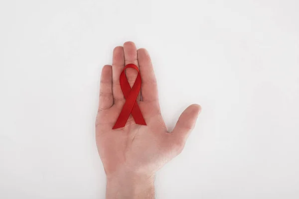 Hand with red aids ribbon — Stock Photo