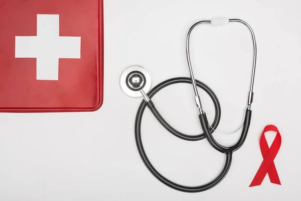 First aid kit, stethoscope and aids ribbon — Stock Photo