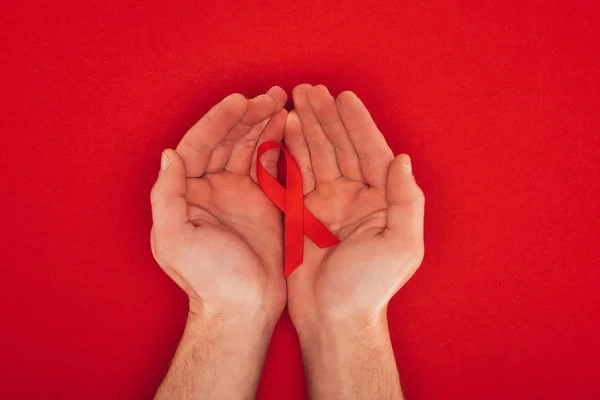 Hands with aids ribbon — Stock Photo