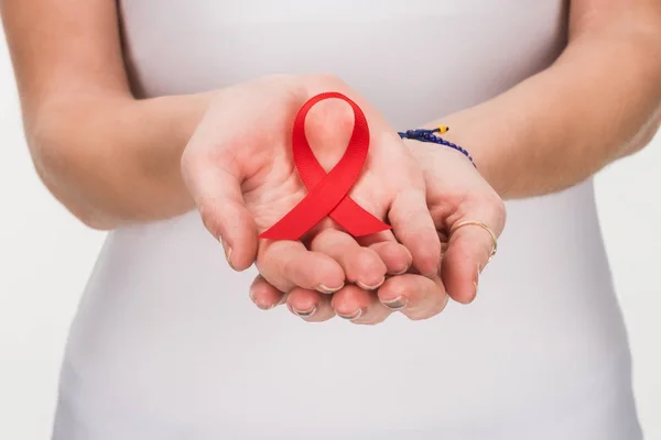 Red aids ribbon in hands — Stock Photo