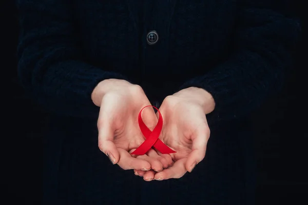 Aids ribbon in hands — Stock Photo