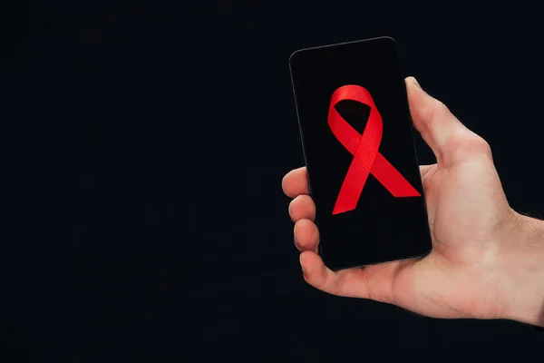 Smartphone with red aids ribbon — Stock Photo