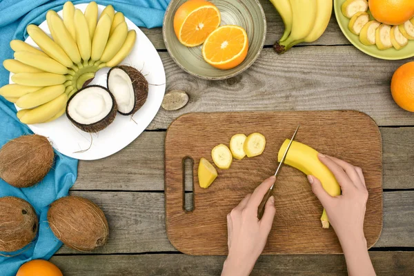 Person slicing banana — Stock Photo