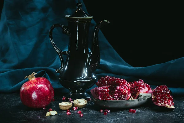 Schwarze Teekanne und Granatäpfel — Stockfoto