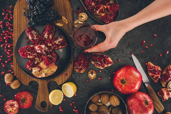 Woman putting glass of pomegranate juice — Stock Photo