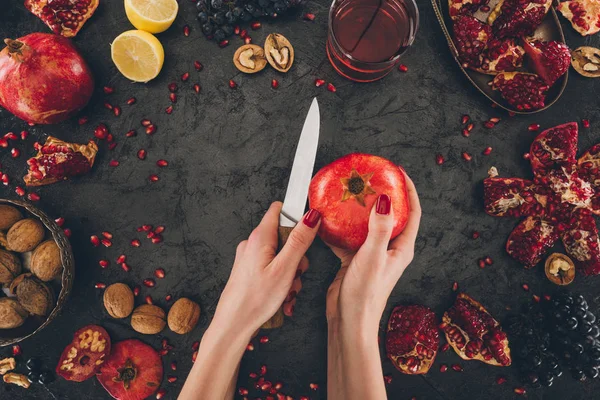 Woman peeling pomegranate — Stock Photo