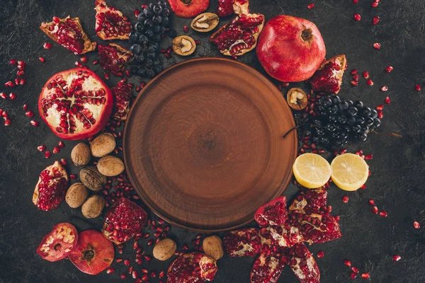 Пустая тарелка среди фруктов — стоковое фото
