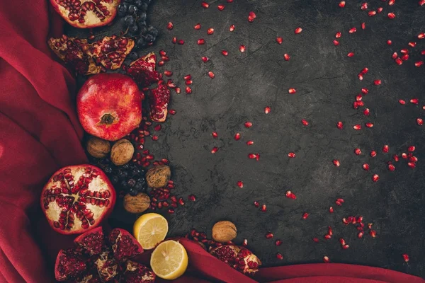 Frutas con nueces y tela roja - foto de stock